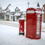 Red post and telephone box in the snow