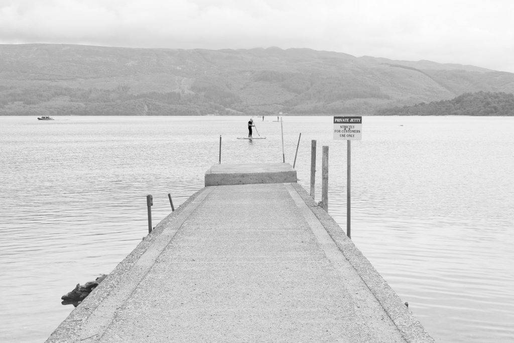 Paddle boarder passes Luss pier