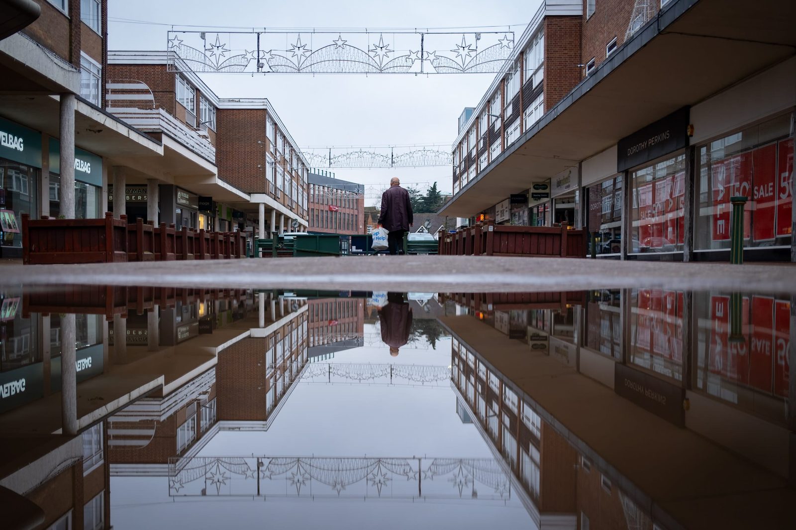 Another lone person reflected in the water